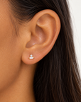 Close-up of a Bajan model wearing the Millie Marquise Stud in gold-plated sterling silver, featuring a white opal marquise stone and sparkling cubic zirconia accent.