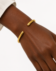 Alessia Bangle in waterproof gold featuring a sleek open bangle design with rounded ends.