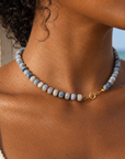Anya Beaded Necklace with blue grey natural stone beads and 18k gold plated titanium clasp worn on model