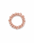 Skinny light pink satin scrunchy hair tie on a clean white background, minimal and lightweight design for everyday use