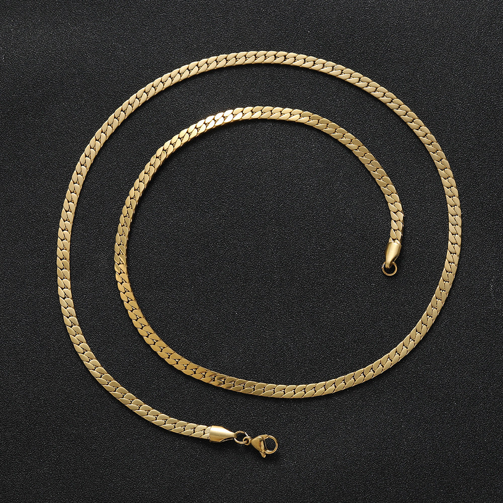 Flat gold men’s chain laying flat on a black background