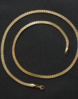 Flat gold men’s chain laying flat on a black background
