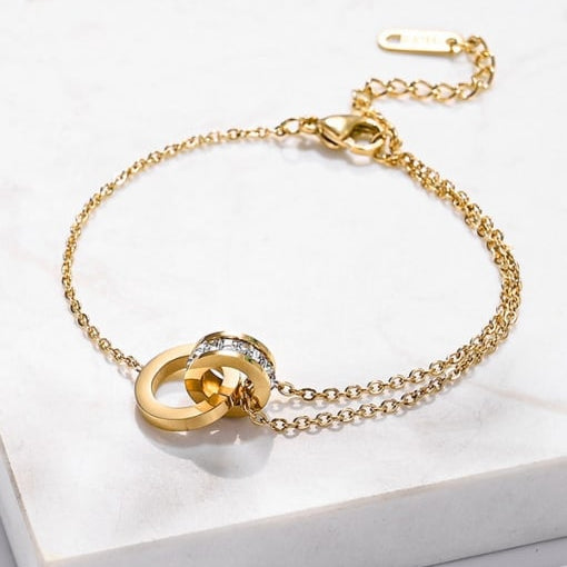Kelly interlocking bracelet in gold stainless steel with cubic zirconia links, featuring a bold, polished and structured design