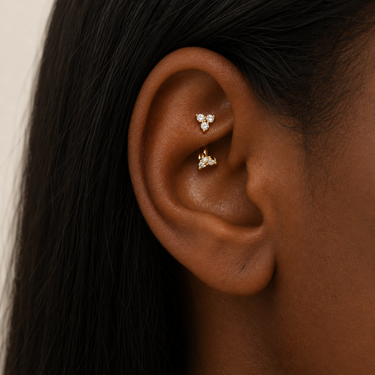Maya duo bar earring in gold with cubic zirconia, 1.45cm curved bar with double clover ends, single stud on white background