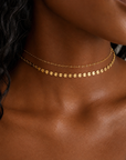 Gold disc necklace in titanium steel with tiny connected discs and cable chain, lightweight layering necklace inspired by Barbados sun